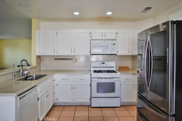 kitchen featuring white appliances, light countertops, a sink, and white cabinets