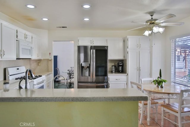 kitchen featuring recessed lighting, visible vents, decorative backsplash, white cabinets, and white appliances