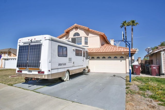 view of front of house featuring driveway, an attached garage, a tiled roof, and stucco siding