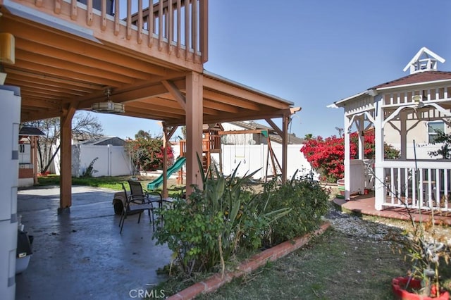 exterior space with a playground and a fenced backyard