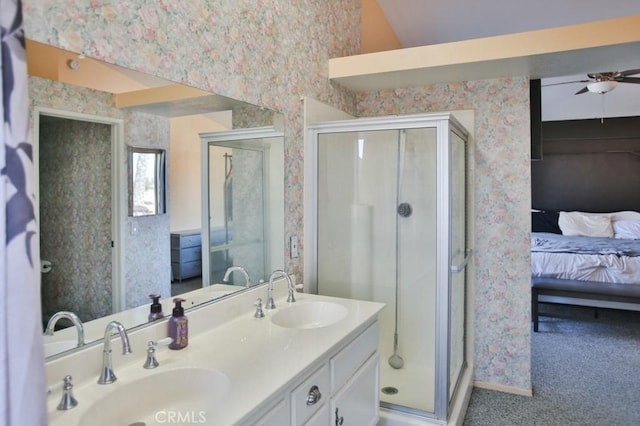 ensuite bathroom featuring a sink, wallpapered walls, ceiling fan, and connected bathroom