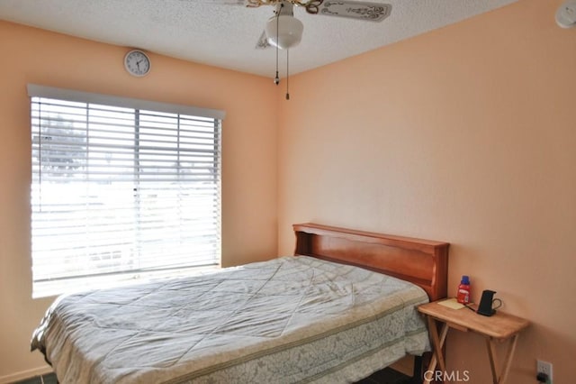 bedroom with a ceiling fan and a textured ceiling