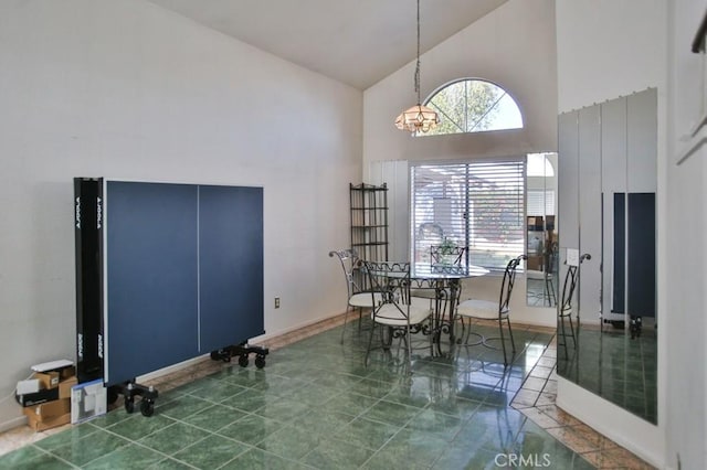 tiled dining space featuring high vaulted ceiling, plenty of natural light, and baseboards