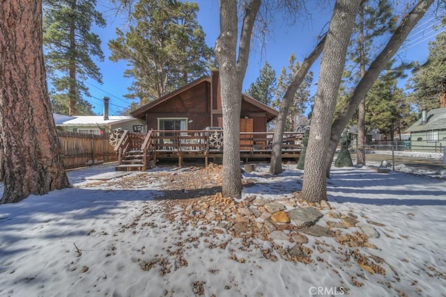 snow covered house with a wooden deck