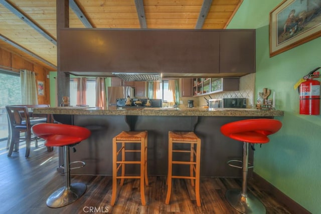 kitchen with a kitchen breakfast bar, kitchen peninsula, and wood ceiling