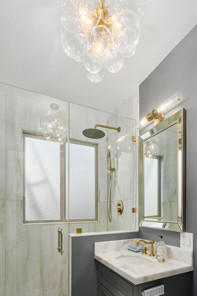 bathroom with a shower with shower door and vanity