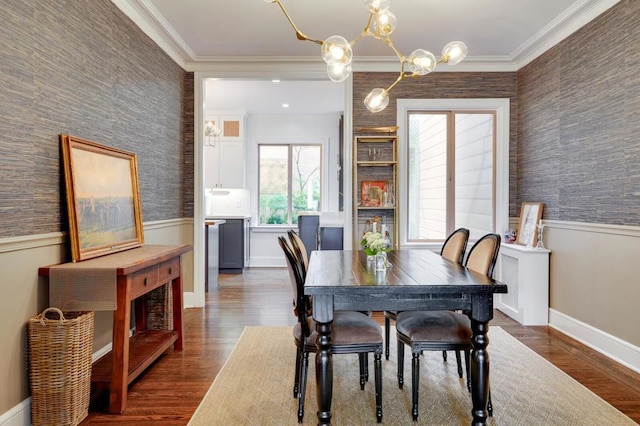 dining area with dark hardwood / wood-style flooring, crown molding, and an inviting chandelier