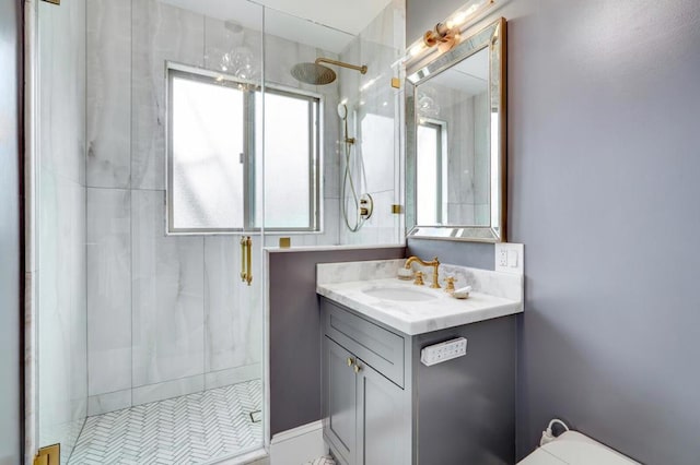 bathroom with a shower with shower door and vanity