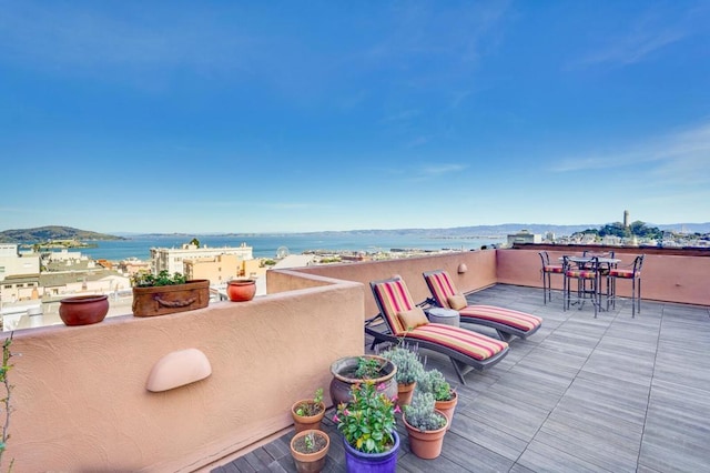 view of patio / terrace with a balcony and a water and mountain view