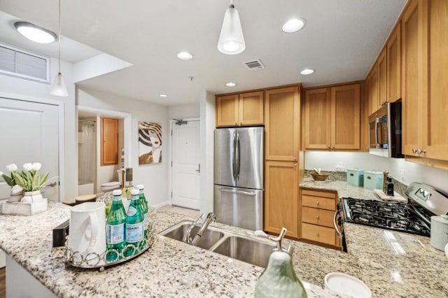 kitchen with hanging light fixtures, sink, kitchen peninsula, and appliances with stainless steel finishes