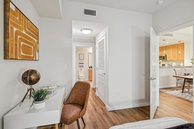 corridor with light hardwood / wood-style floors