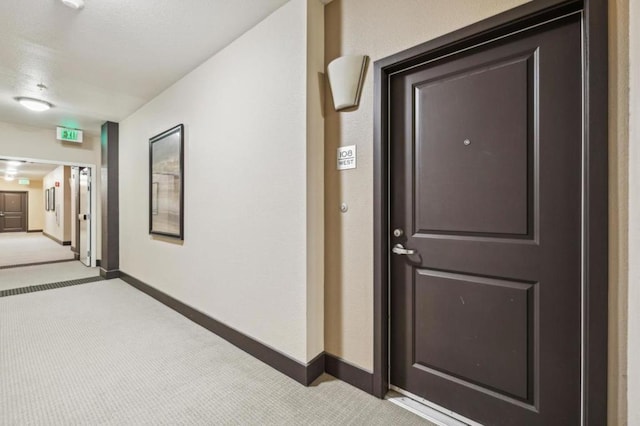 hallway featuring light colored carpet