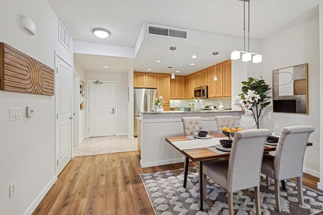 dining area featuring light wood-type flooring