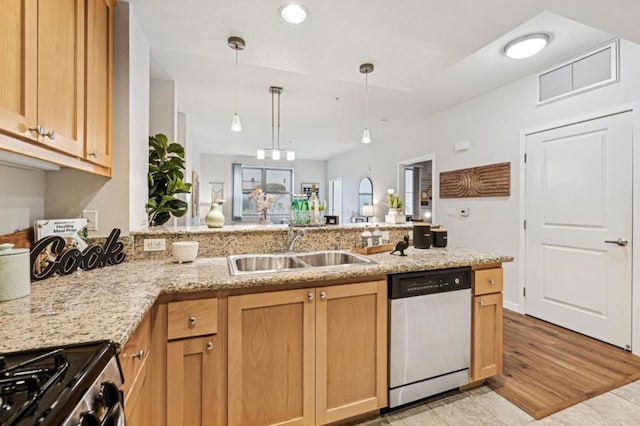 kitchen featuring appliances with stainless steel finishes, pendant lighting, sink, light stone counters, and kitchen peninsula