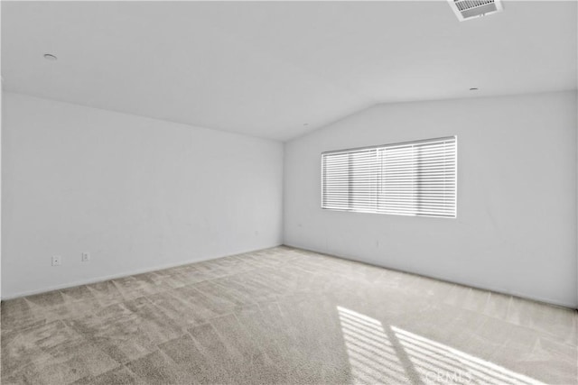 empty room featuring lofted ceiling and light carpet