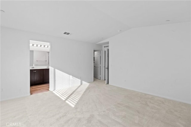 carpeted empty room featuring lofted ceiling