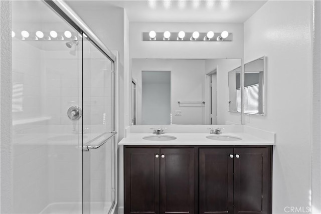 bathroom with a shower with shower door and vanity