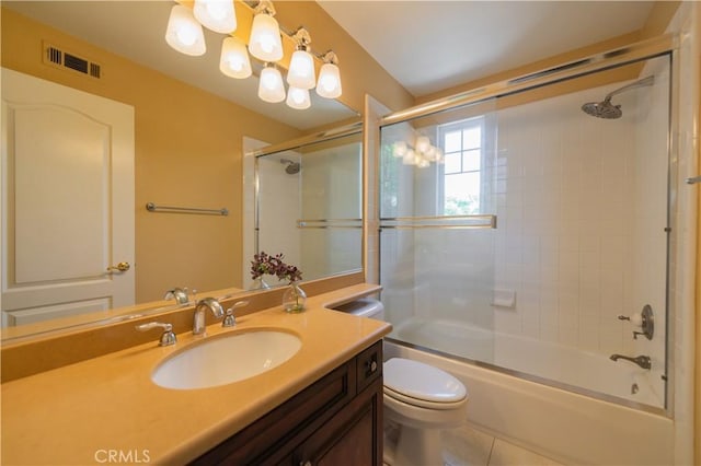 full bathroom with tile patterned floors, bath / shower combo with glass door, toilet, and vanity