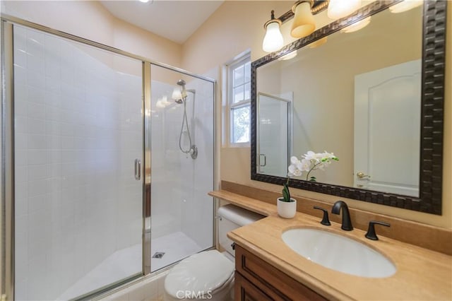 bathroom featuring vanity, toilet, and a shower with door