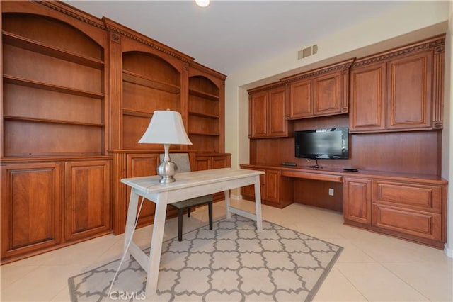 home office with light tile patterned floors and built in desk