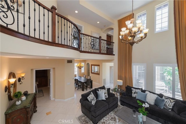 living room with an inviting chandelier, light tile patterned floors, and a high ceiling