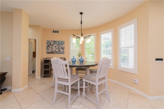 tiled dining space featuring a notable chandelier