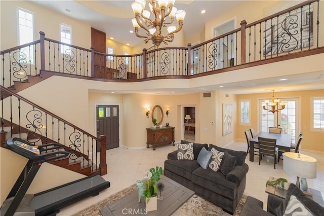 living room with light tile patterned flooring, a towering ceiling, and an inviting chandelier