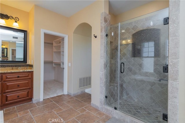 bathroom featuring vanity and a shower with door