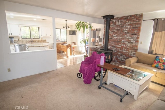 living room featuring light carpet and a wood stove