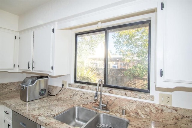 kitchen featuring light stone countertops, sink, white cabinets, and dishwasher