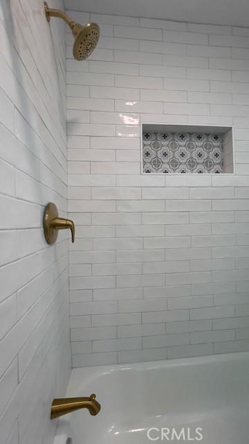 bathroom with tiled shower / bath combo