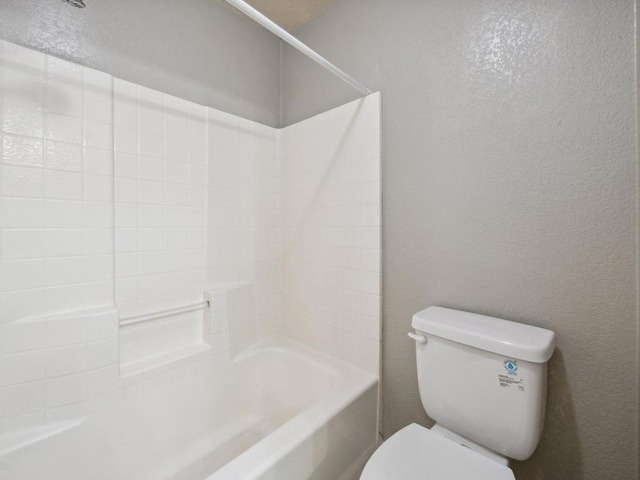 bathroom featuring bathtub / shower combination and toilet