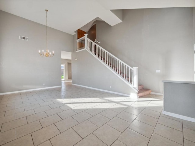 unfurnished living room with light tile patterned floors, a notable chandelier, and a towering ceiling