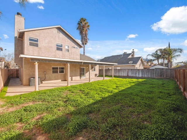 back of property with a yard and a patio