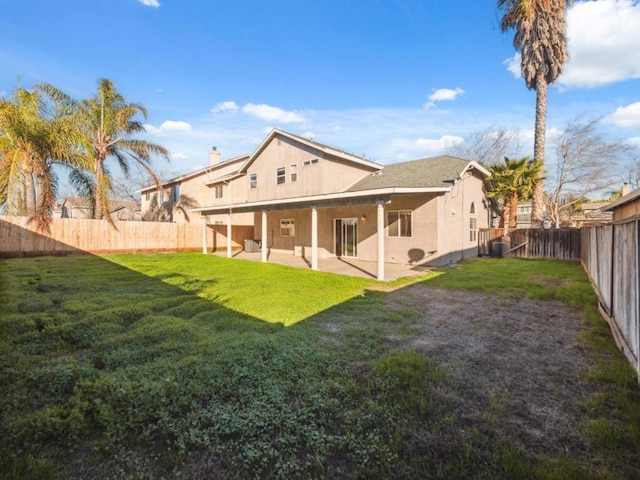 back of house featuring central air condition unit, a yard, and a patio