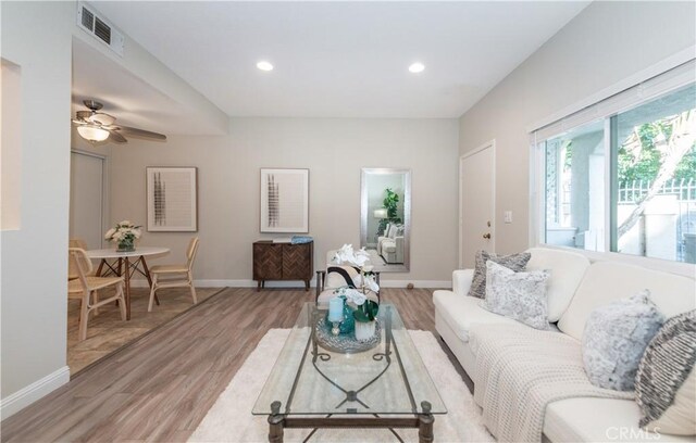 living room with ceiling fan and light wood-type flooring