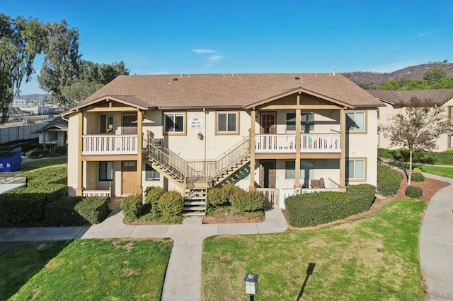 exterior space featuring a balcony and a front yard