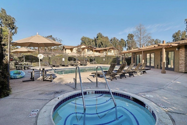 view of pool with a hot tub and a patio