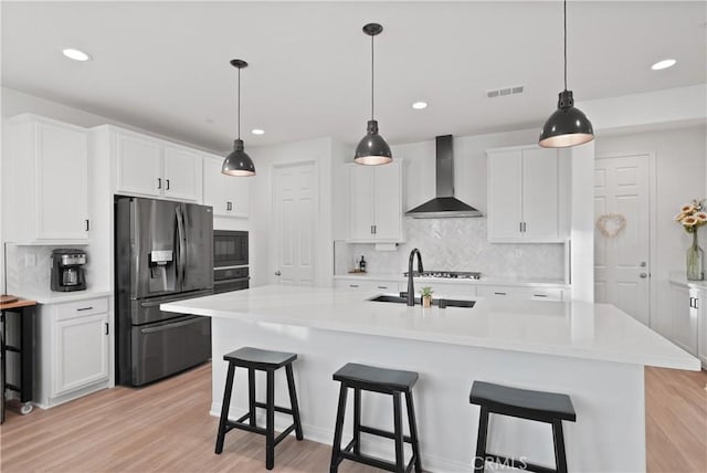 kitchen featuring stainless steel fridge with ice dispenser, wall chimney exhaust hood, white cabinets, and backsplash