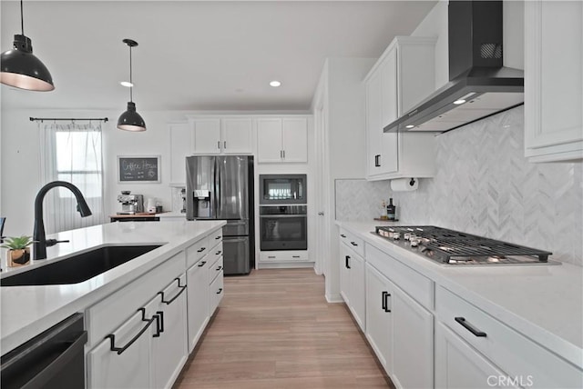 kitchen featuring sink, white cabinetry, black appliances, and wall chimney exhaust hood