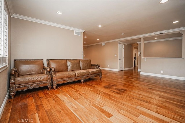 living room with ornamental molding and light hardwood / wood-style flooring