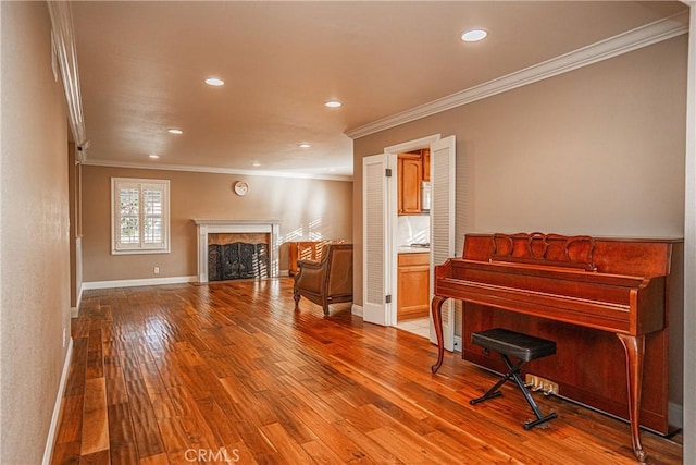 misc room featuring a high end fireplace, ornamental molding, and wood-type flooring