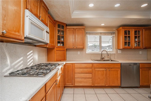 kitchen with tasteful backsplash, a raised ceiling, sink, crown molding, and appliances with stainless steel finishes