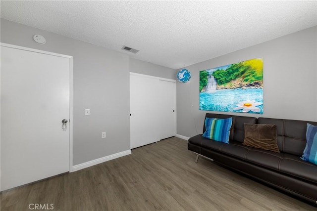 living room with a textured ceiling and hardwood / wood-style floors