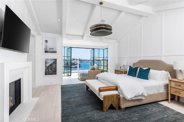 bedroom featuring a wall of windows, hardwood / wood-style flooring, and lofted ceiling with beams