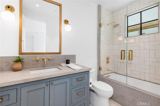 full bathroom with toilet, vanity, and shower / bath combination with glass door