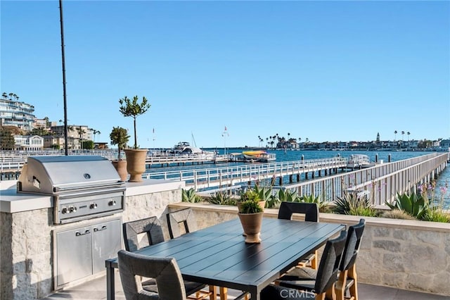 view of patio with a water view and a grill