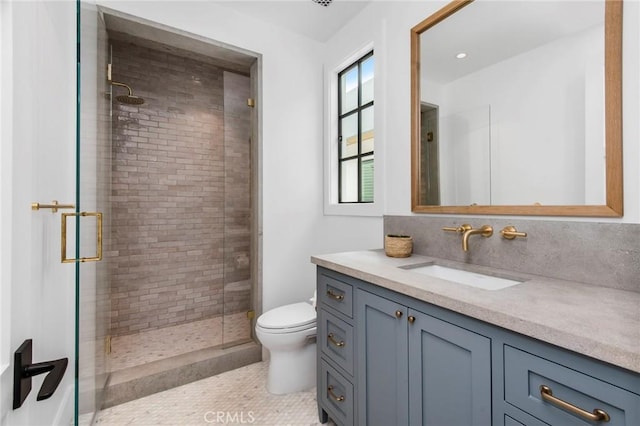 bathroom featuring toilet, tile patterned flooring, walk in shower, and vanity