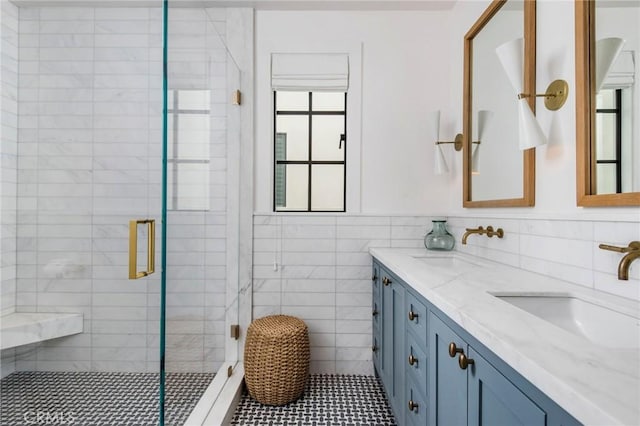 bathroom with vanity, tile walls, and a shower with door