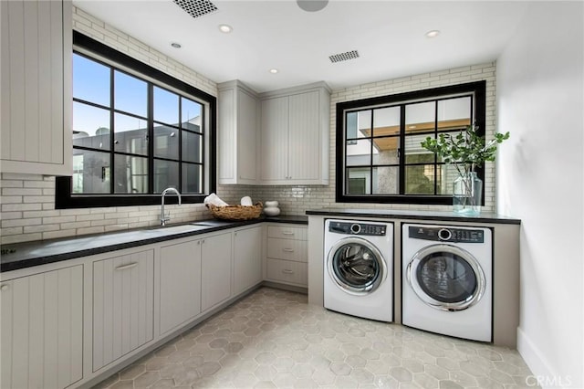 laundry room with cabinets, washer and dryer, and sink